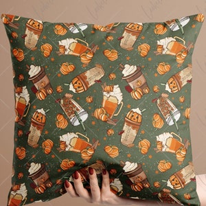May include: Green throw pillow with a fall-themed pattern featuring pumpkins, coffee cups, and cinnamon sticks.