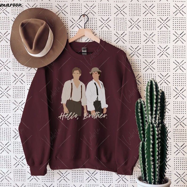 May include: A maroon sweatshirt featuring a graphic of two men wearing braces and the text "Hello, Brother."