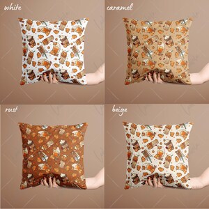 May include: Four square throw pillows with different colored backgrounds and a pattern of fall-themed coffee cups and pumpkins. The colors are white, caramel, rust, and beige.