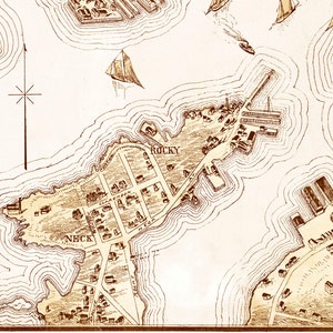 May include: An antique map of a coastal area with a compass rose and the words "Rocky Neck" and "Rocky" printed on the map.