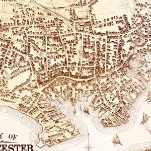 May include: An antique map of the city of Worcester, Massachusetts, with detailed streets and buildings. The map is drawn in brown ink on a cream-colored background. The map shows the city's harbor and surrounding waterways.
