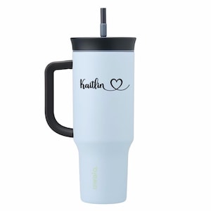 May include: A light blue insulated tumbler with a black handle, lid, and straw. The tumbler features the name "Kaitlin" with a heart symbol in black script. The brand name "owala" is printed at the bottom.