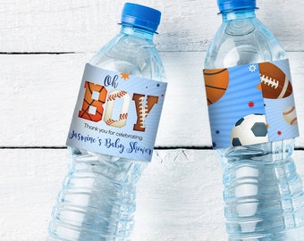 May include: Three clear plastic water bottles with blue caps and labels. The labels say "Oh Boy" with sports-themed graphics and "Thank you for celebrating Jasmine's Baby Shower."