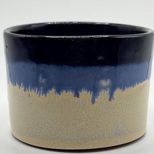 May include: A ceramic planter with a dark blue glaze at the top, a light blue glaze in the middle, and a light beige glaze at the bottom.