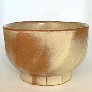 May include: A small, brown and cream ceramic bowl with a scalloped rim. The bowl has a mottled glaze and a slightly irregular shape.