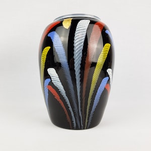 May include: Black ceramic vase with a geometric design of colorful lines and stripes in shades of red, yellow, blue, and white.
