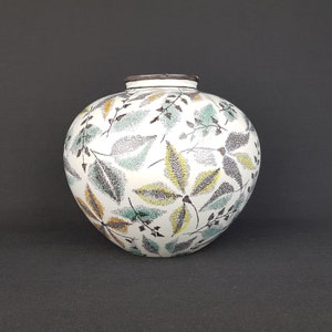 Pode incluir: Vaso de cerâmica branco com corpo redondo e um padrão de folhas em tons de verde, marrom e amarelo.