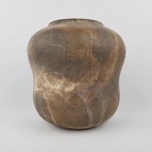 Könnte beinhalten: Eine braune Keramikvase mit rundem Körper und schmalem Hals. Die Vase hat eine strukturierte Oberfläche mit marmoriertem Aussehen, mit Brauntönen und Beige. Die Vase ist etwa 25 cm hoch.