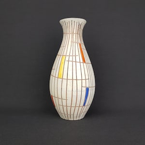 Könnte beinhalten: Eine weiße Keramikvase mit einem geometrischen Muster aus braunen, orangen, gelben und blauen Linien. Die Vase hat einen abgerundeten Boden und einen schmalen Hals.