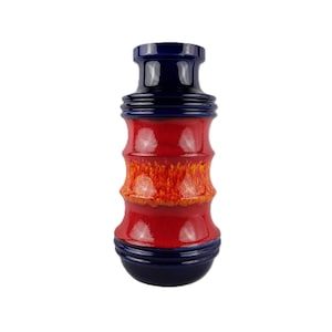 May include: A vintage ceramic vase with a cylindrical shape. The vase has a glossy finish in dark blue, red, and orange. The design includes horizontal bands of colour and a textured, speckled pattern.