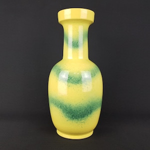 Peut inclure: Un vase en céramique jaune avec des rayures vertes. Le vase a un corps rond et un col étroit.