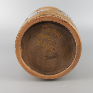 Puede incluir: La parte inferior de un jarr&oacute;n de terracota con una inscripci&oacute;n dorada que dice "Capri Italia 826".