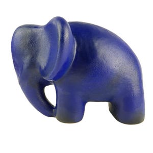 May include: A blue ceramic elephant figurine. The elephant is standing with its trunk curled up.
