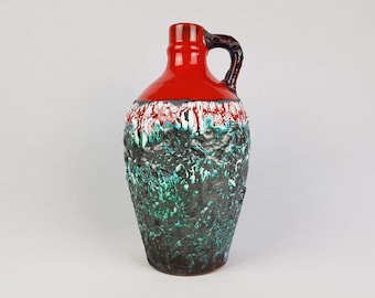 Könnte beinhalten: Eine rote und grüne Keramikvase mit einer strukturierten Oberfläche und einem Henkel. Die Vase hat eine gefleckte Glasur in Rot-, Grün-, Weiß- und Schwarztönen.