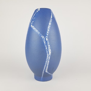 May include: A blue ceramic vase with a white abstract design. The vase is oval shaped and has a narrow opening.