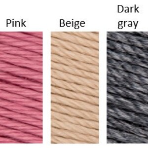 May include: Five yarn skeins in different colors: deep orange, pink, beige, dark gray, and light gray.