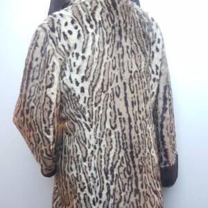 May include: A brown and white leopard print faux fur coat with a brown collar and cuffs.