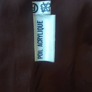 May include: White fabric label with black text that reads "POIL ACRYLIIQUE".