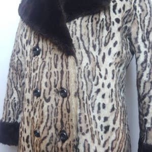 May include: A brown and white leopard print faux fur coat with a brown faux fur collar and cuffs. The coat has a double breasted closure with black buttons.