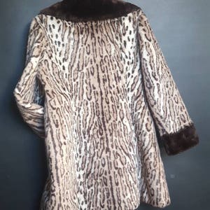 May include: A brown and white leopard print faux fur coat with a brown faux fur collar and cuffs.