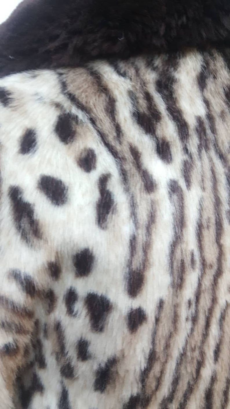 May include: Close-up of a white and brown faux fur fabric with a leopard print pattern.