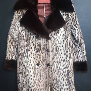 May include: A brown and white leopard print faux fur coat with a brown faux fur collar and cuffs.