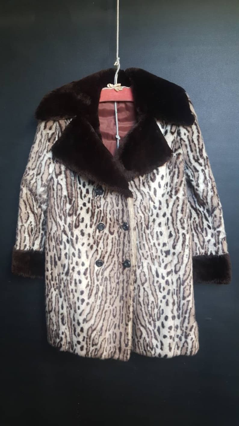 May include: A brown and white leopard print faux fur coat with a brown faux fur collar and cuffs.