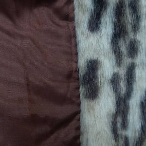 May include: Close-up of a brown fabric with a white and black leopard print fabric sewn to the right side.