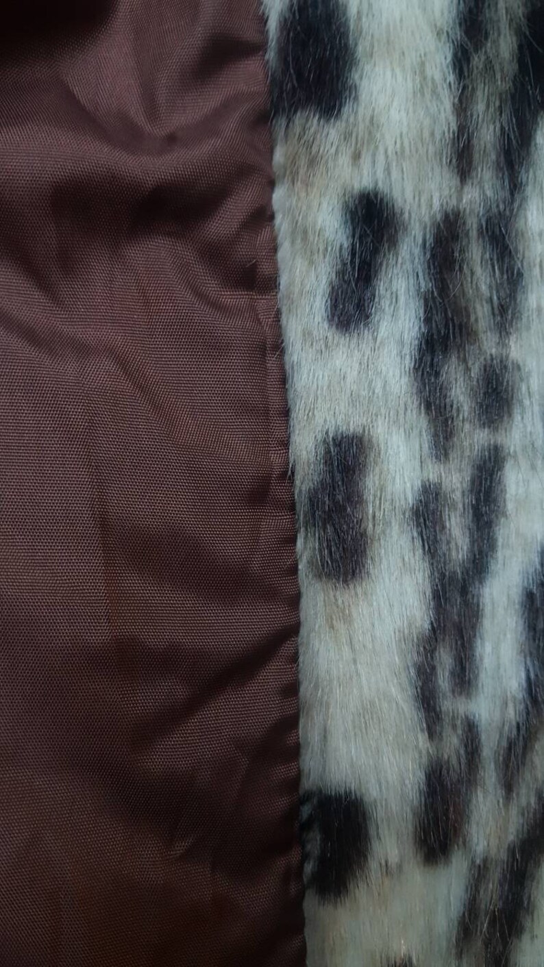 May include: Close-up of a brown fabric with a white and black leopard print fabric sewn to the right side.