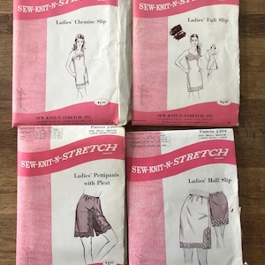 May include: Four vintage sewing patterns for ladies' undergarments. The patterns are printed on pink paper with illustrations of the garments. The patterns are from Sew-Knit-N-Stretch, Inc. and include a chemise slip, full slip, pettipants with pleat, and half slip. Each pattern costs $1.00.