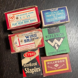 Puede incluir: Surtido de cajas vintage de clavos, grapas, chinchetas y clavos de alambre. Las cajas son rojas, azules, verdes y negras con letras blancas. Las cajas están etiquetadas con las marcas "USS", "Eagle", "Columbia", "Cross" y "Hillwood".