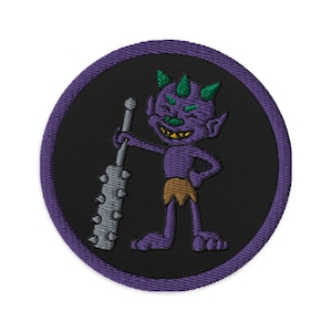 Può includere: Toppa ricamata viola con un cartone animato di un diavolo viola che tiene un bastone spinato. Il diavolo ha corna verdi e un sorriso malizioso.