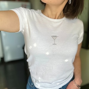 Disco Ball Martini Baby Tee | Minimalist Aesthetic Boozy Dirty Martini with Disco Ball Garnish T-Shirt | Bachelorette Y2K 90s Women&#39;s Tee