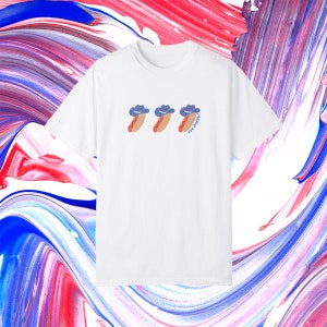 a white t-shirt with a graphic of 3 consecutively lined up hot dogs wearing red, white, and blue star-patterned cowboy hats, with the words “Yee doggy” in blue under the third hotdog in the center of the chest area