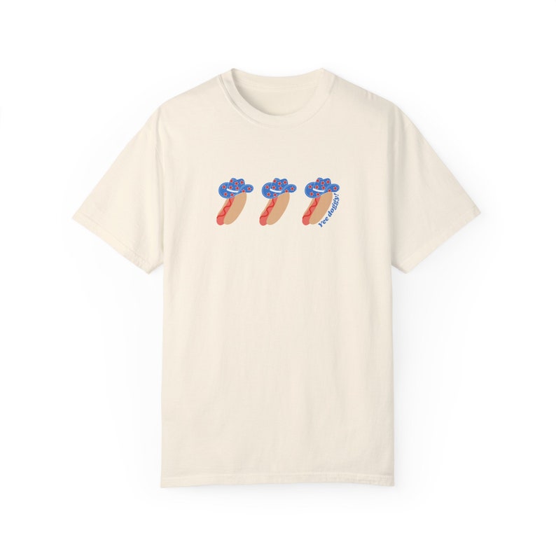 an ivory t-shirt with a graphic 3 hot dogs with red, white, and blue cowboy hats
