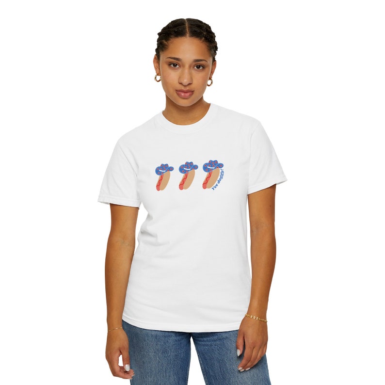 woman wearing an oversized Comfort Colors t-shirt with a graphic 3 hot dogs with red, white, and blue cowboy hats