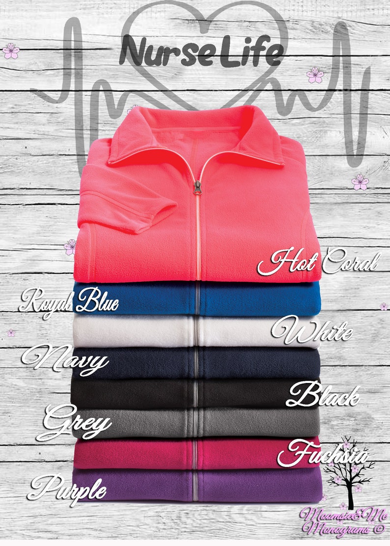 May include: A stack of fleece zip-up jackets in various colors, including hot coral, royal blue, white, navy, grey, fuchsia, and purple. The jackets are arranged from top to bottom, with the hot coral jacket on top. The text "Nurse Life" is written in a heart shape above the jackets.