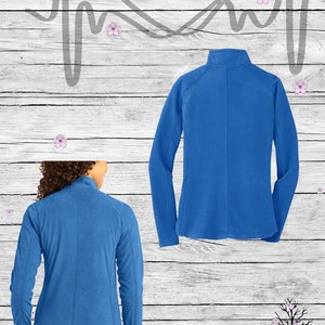 May include: A royal blue fleece jacket with a zipper closure. The jacket is shown from the front and back. The text "Nurse Life" is written in a heart shape above the jacket.