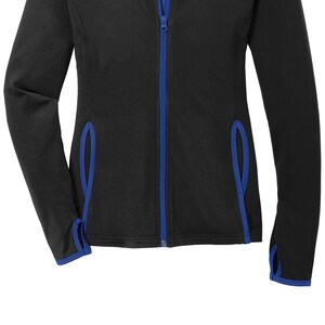 May include: Black zip-up jacket with blue trim around the edges and down the zipper.