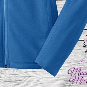 May include: A blue fleece jacket with a zipper closure and a white background.