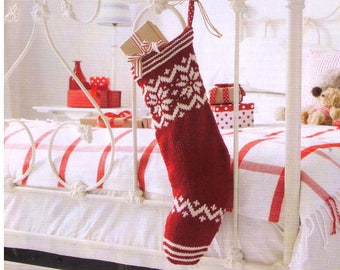 May include: A red and white knitted Christmas stocking with a snowflake pattern hangs on a white metal bed frame. The stocking is filled with wrapped gifts.