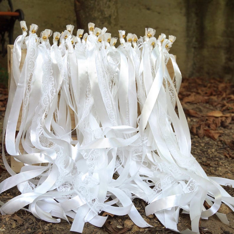 White wedding ribbon wand with lace and satin streamers, gold bell send off stick.