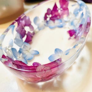 Oval resin bowl with dried purple and blue flowers