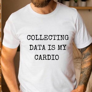 May include: White t-shirt with black text that reads "COLLECTING DATA IS MY CARDIO".