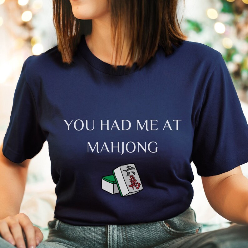 May include: A navy blue t-shirt with the text "You had me at Mahjong" and a graphic of two mahjong tiles.