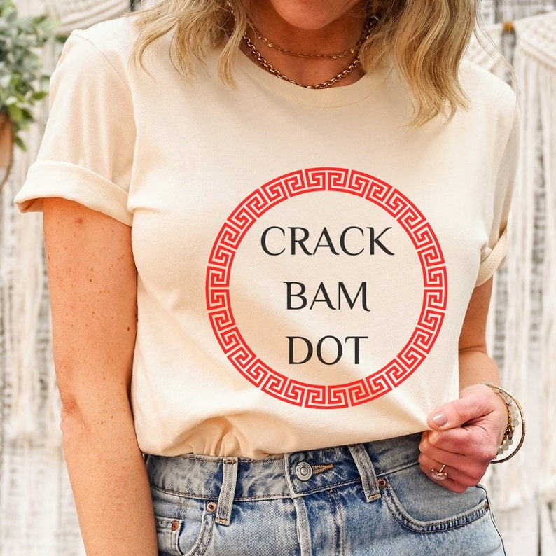May include: A cream colored t-shirt with a red circle and the text "CRACK BAM DOT" inside the circle.