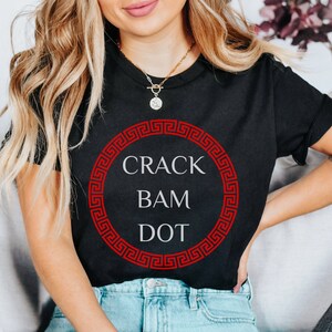 May include: Black t-shirt with a red Greek key design circle and the text "CRACK BAM DOT" in white.