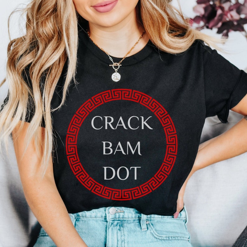 May include: Black t-shirt with a red Greek key design circle and the text "CRACK BAM DOT" in white.