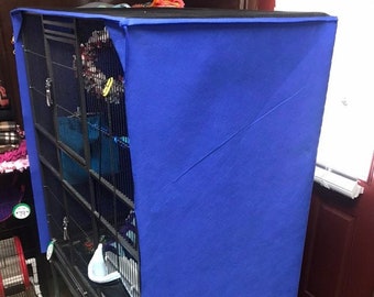 May include: A blue fabric cage cover for a large bird cage. The cage is made of metal and has multiple levels. The cover is made of a soft, blue fabric and has a black trim.