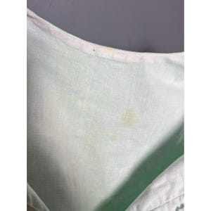 May include: A white ceramic mug with a black handle and the text "But First, Coffee" in a black, handwritten-style font. The mug is on a white surface.